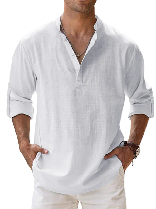 Man wearing a white linen shirt with rolled-up sleeves against a light blue background