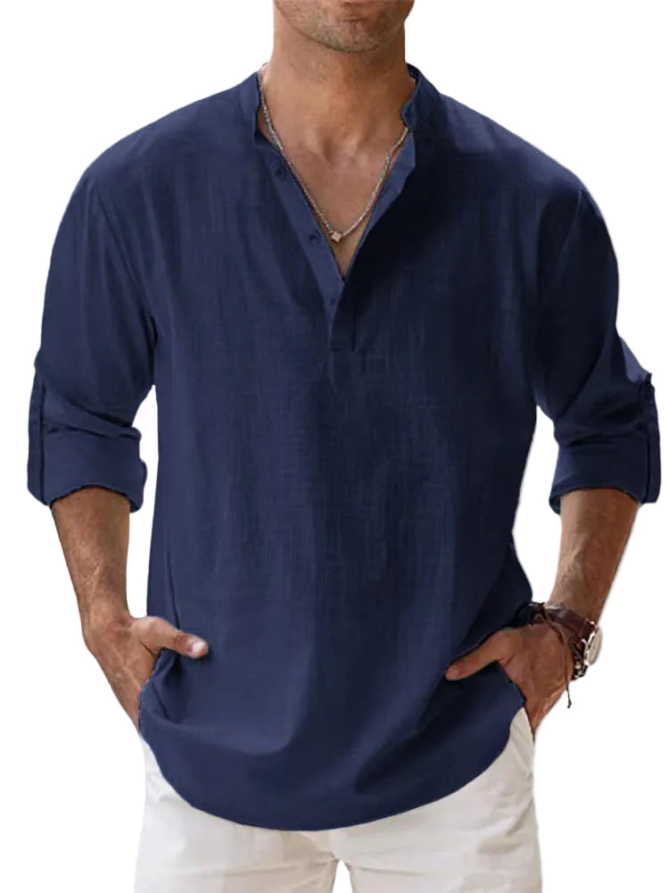 Man wearing a navy blue shirt with rolled-up sleeves against a light background