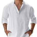 Man wearing a white linen shirt with rolled-up sleeves against a light background