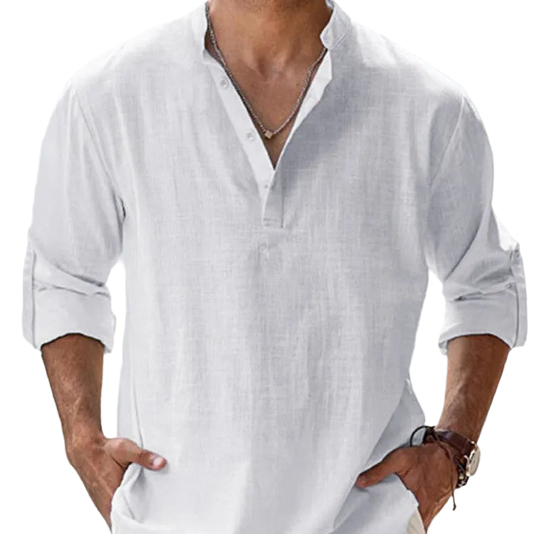 Man wearing a white linen shirt with rolled-up sleeves against a light background