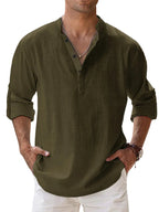 Man wearing an olive green shirt with rolled-up sleeves against a light blue background