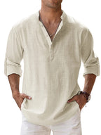 Man wearing a beige shirt with rolled-up sleeves against a blurred background