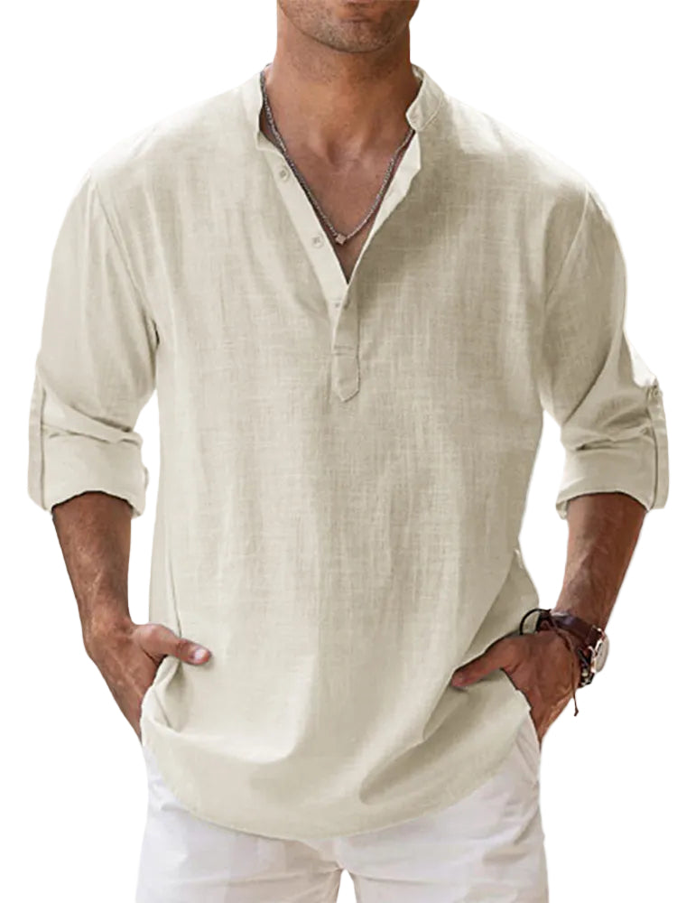 Man wearing a beige shirt with rolled-up sleeves against a blurred background