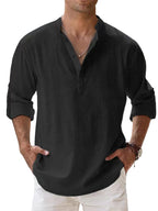 Man wearing a black shirt with rolled-up sleeves against a light background
