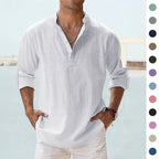 Man wearing a white linen shirt with rolled-up sleeves against a light blue background