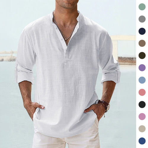 Man wearing a white linen shirt with rolled-up sleeves against a light blue background