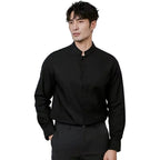 Man wearing a black shirt and pants against a plain background