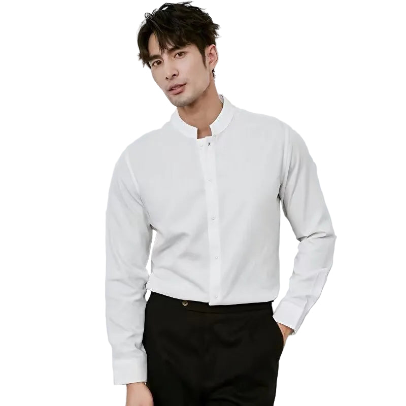Man wearing a white shirt and black pants against a light gray background