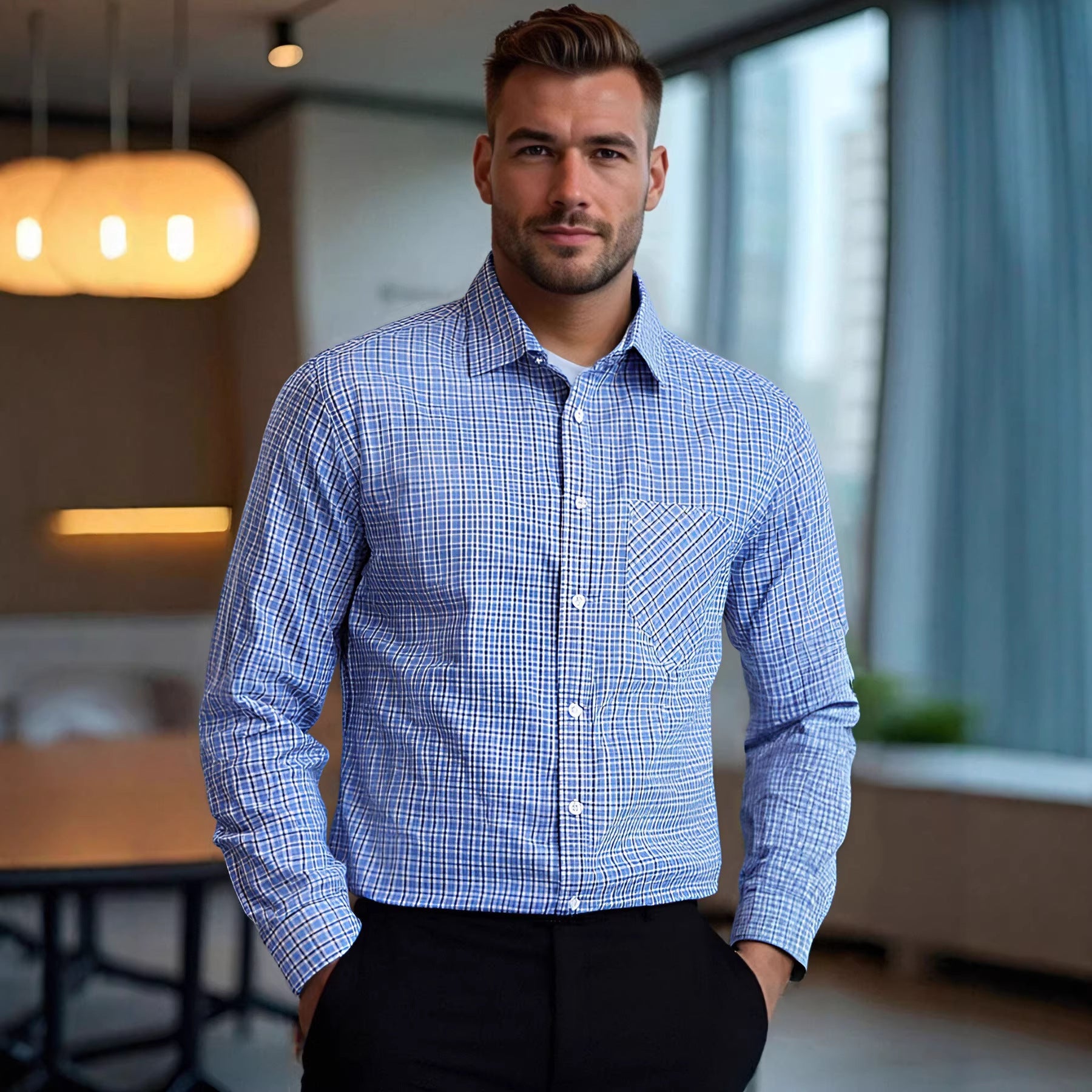Man wearing a blue checkered shirt in an indoor setting