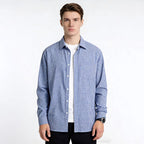 Man wearing a blue checkered shirt over a white t-shirt on a white background