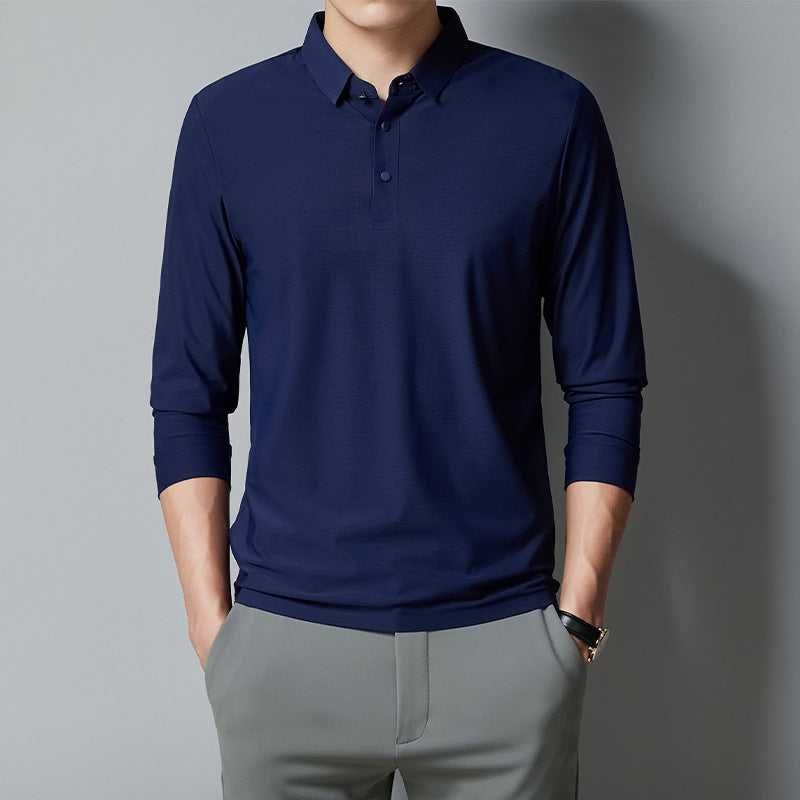 Person wearing a navy long-sleeve polo shirt and gray pants against a gray background