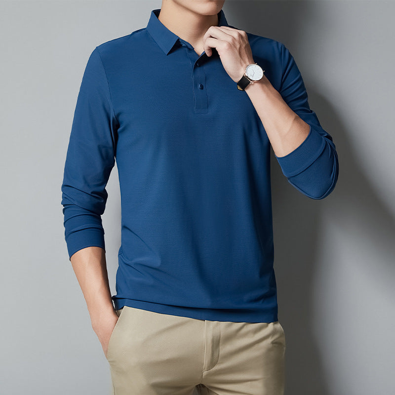 Person wearing a blue long-sleeve polo shirt and beige pants against a gray background
