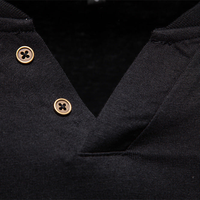 Close-up of a black garment with gold buttons on a dark background